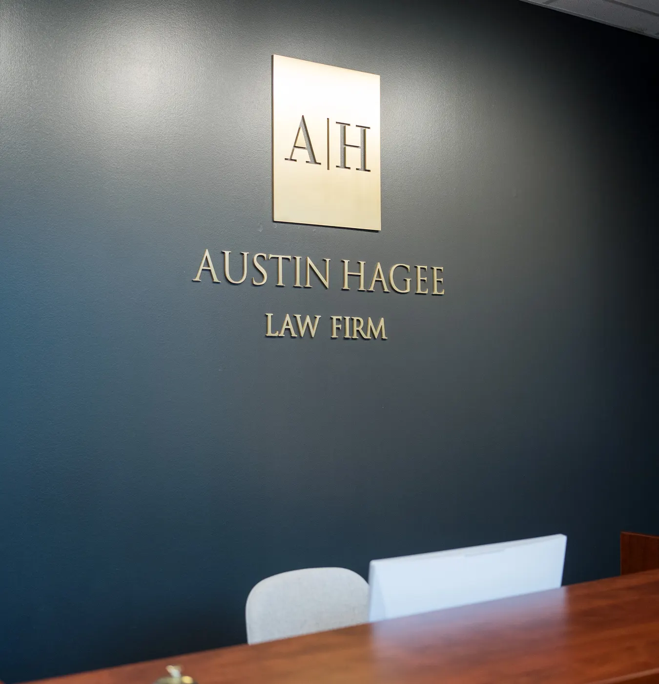 The Austin Hagee Law Firm sign on the wall of the firm’s San Antonio office