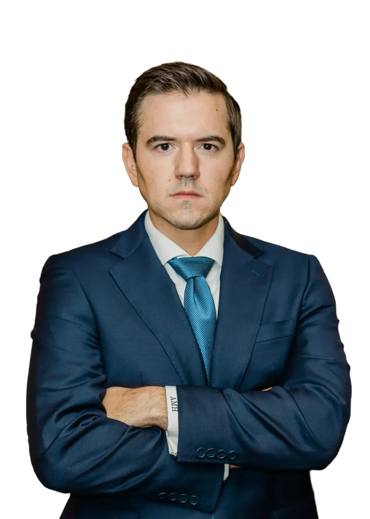 Attorney Austin Hagee in a navy suit and blue tie standing with his arms folded