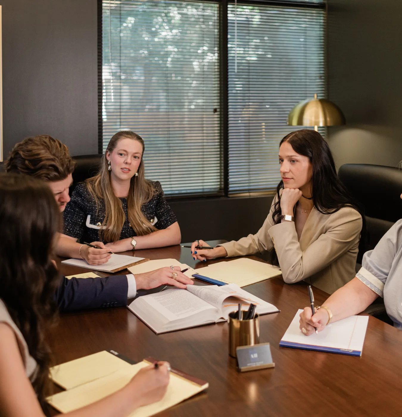 The firm's team reviewing an open case file around the conference table