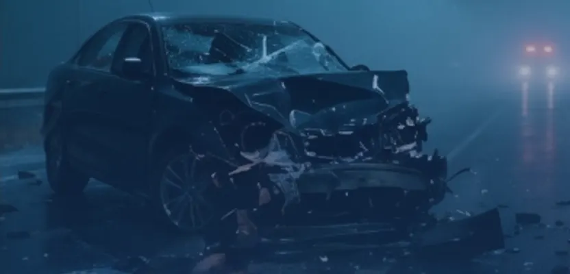 A wrecked car on a wet street after a night-time crash