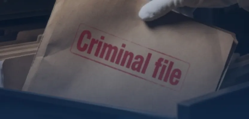 A hand lifting a folder stamped Criminal file out of a drawer